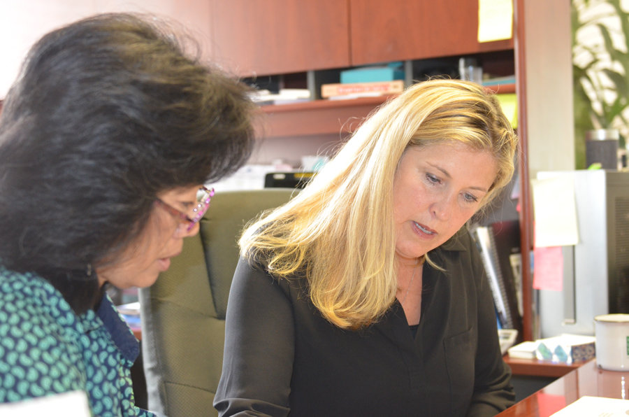 Administrative assistant Kyong Bertsch at work with Tracy Stirrett, right.