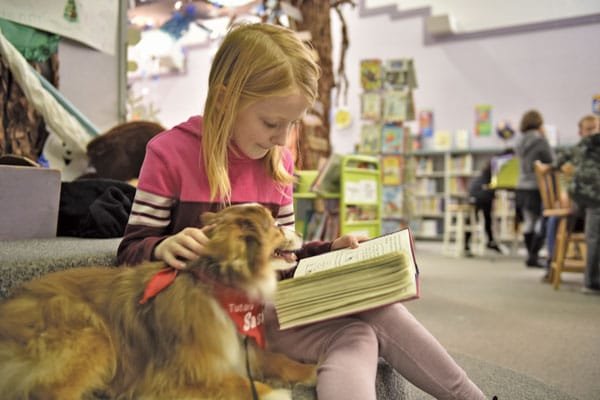 Third-grade student Scarlett Struthers enjoys reading aloud with Sasha.