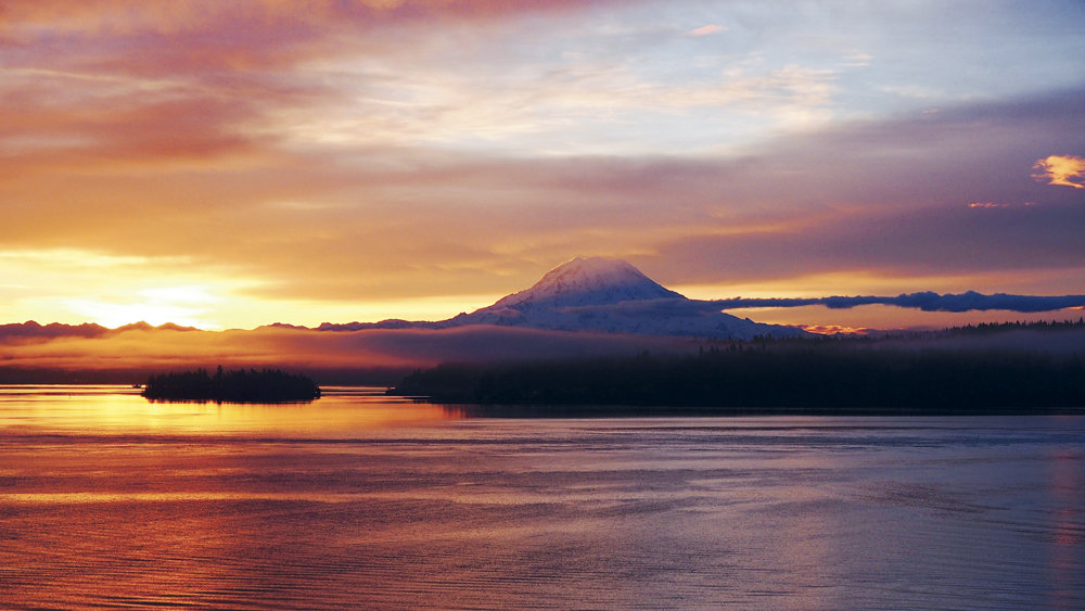 The sun rises over Eagle Island and Mount Rainer as seen from Filucy Bay. Photo: Richard Hildahl