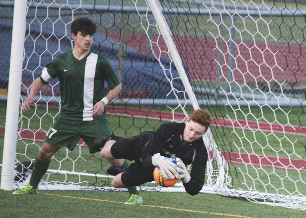 Peninsula High School goalie Benjamin Undem makes a diving save for his team in a 2-1 victory over North Thurston soccer April 13. Photo: Ed Johnson, KP News