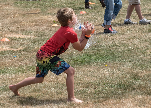 Max Mcloughlin “catches” a water balloon during the KP Parks Fourth of July hot dog social at Volunteer Park. Photo: Ed Johnson, KP News