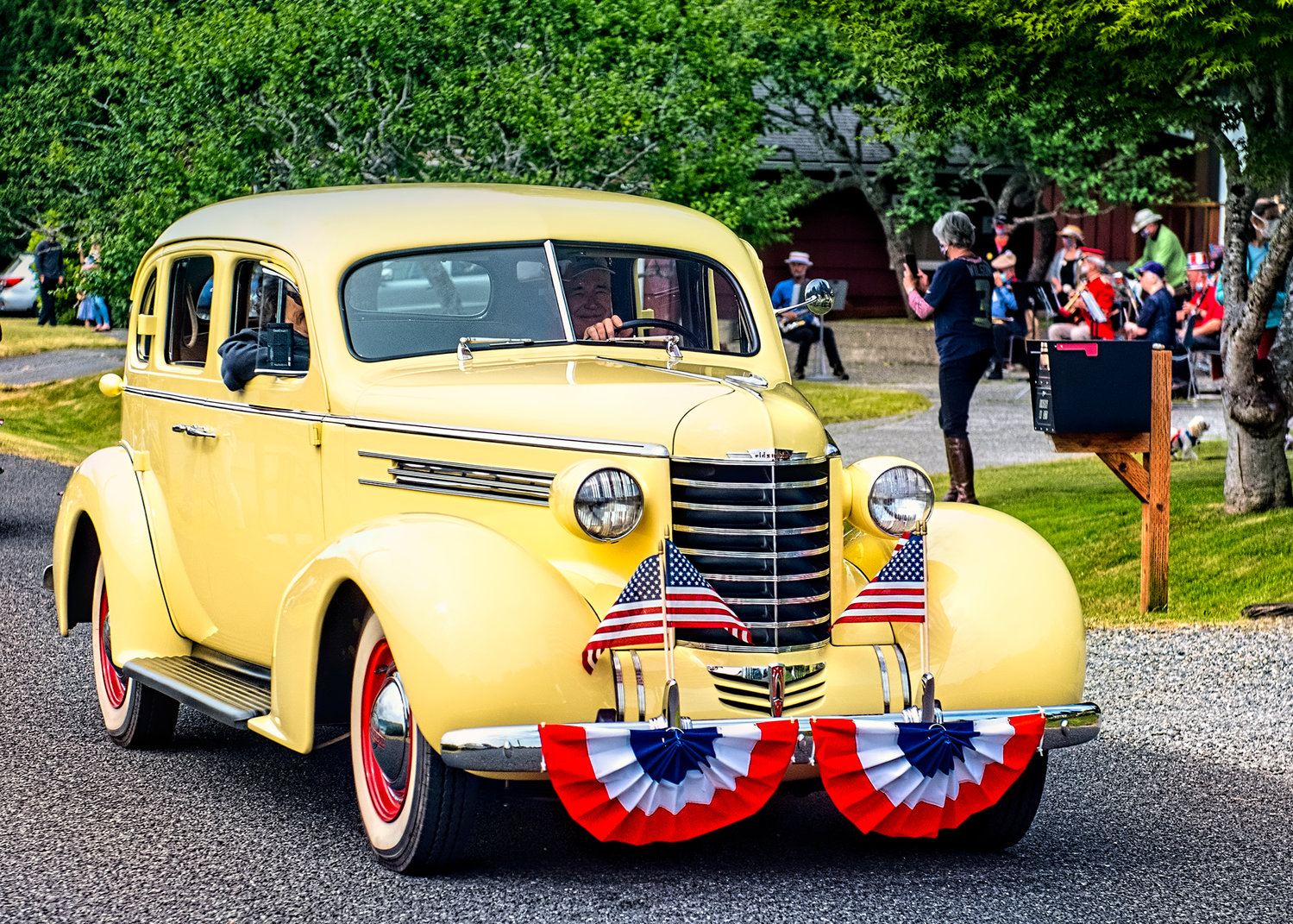 A gorgeous roadster tours the Fourth of July parade route in Home.