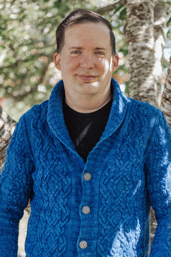 Premiere lace knitter Peter Rowe wears his favorite sweater “Radmere” knit with Malabrigo Rios yarn in Matisse Blue.