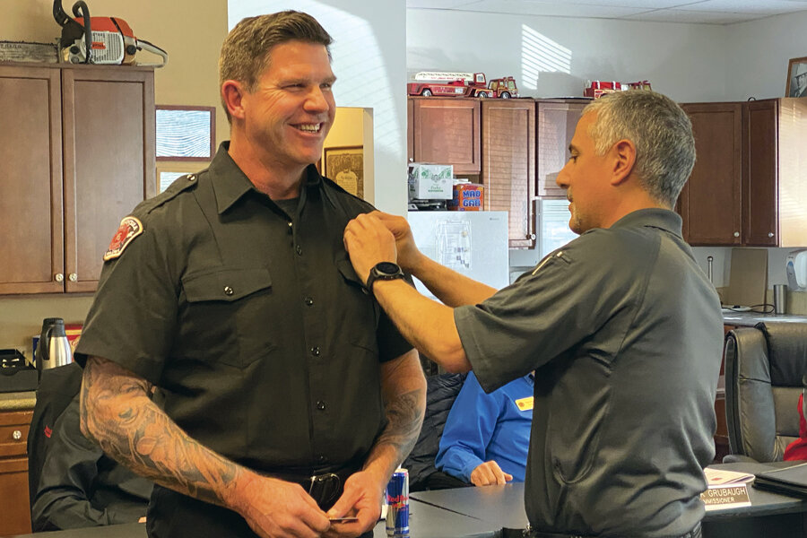 Assistant Chief Christopher Beswick receives his badge April 11 from Fire Chief Nick Swinhart.