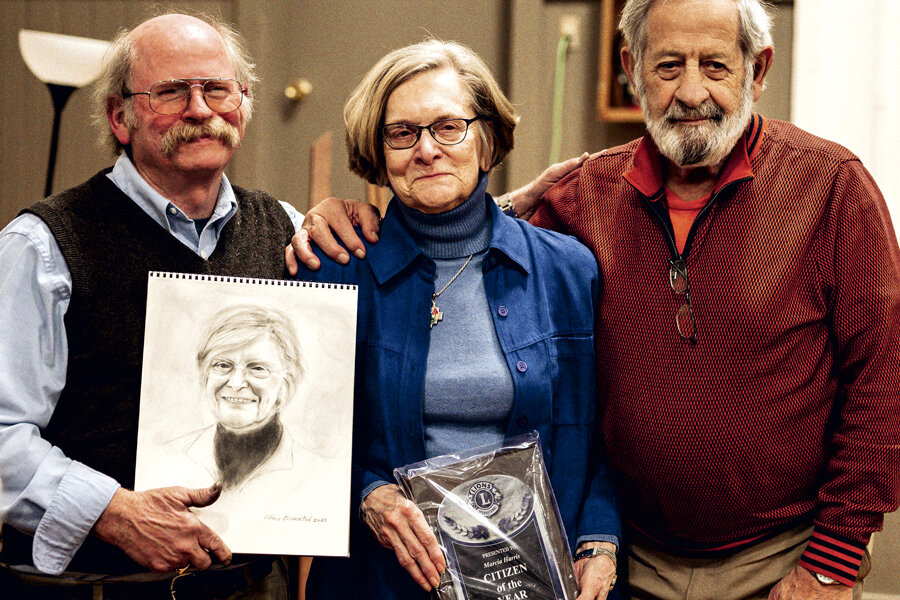 Artist Chris Bronstad, left, with his portrait of Marcia Harris, center, and her husband, Jeff.