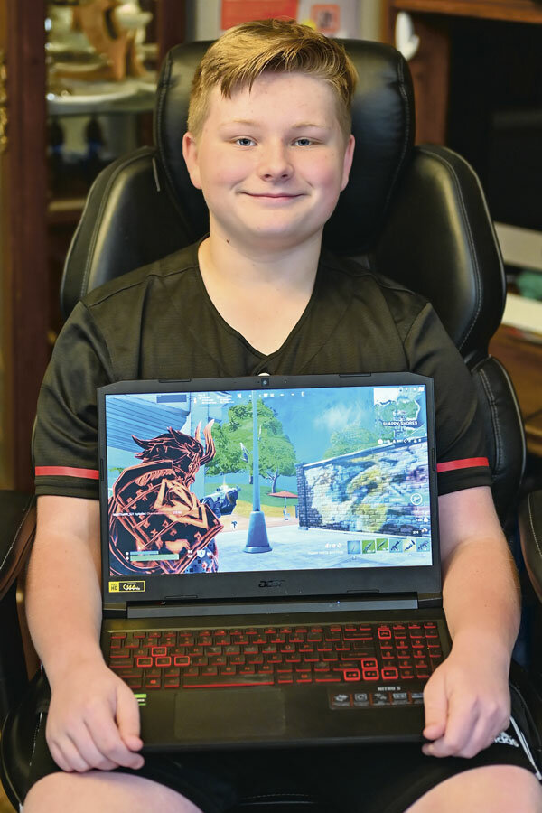 Bryce Hoover at home with one of his Fortnite “skins.”
