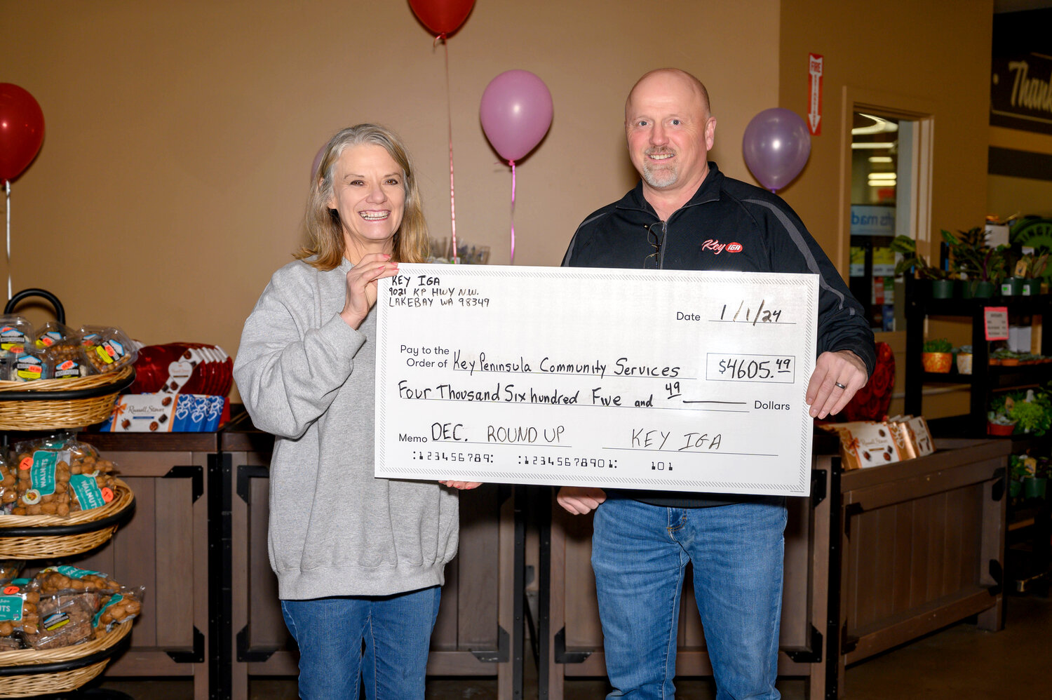 Key IGA Manager Kip Bonds presents a check to Key Peninsula Community Services Volunteer Coordinator Teresa Conness from month-long Round-Up campaign for KPCS.